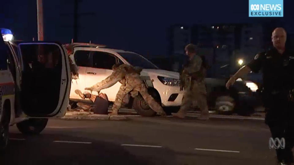 In a supplied screen grab obtained on Tuesday, June 4, 2019, Members of the Territory Response Group (TRG) arrest a suspected gunman in Darwin. Four people are dead after a shooting in Darwin on Tuesday night, and a suspected gunman has been arrested. (AAP Image/Supplied by ABC News) NO ARCHIVING, EDITORIAL USE ONLY