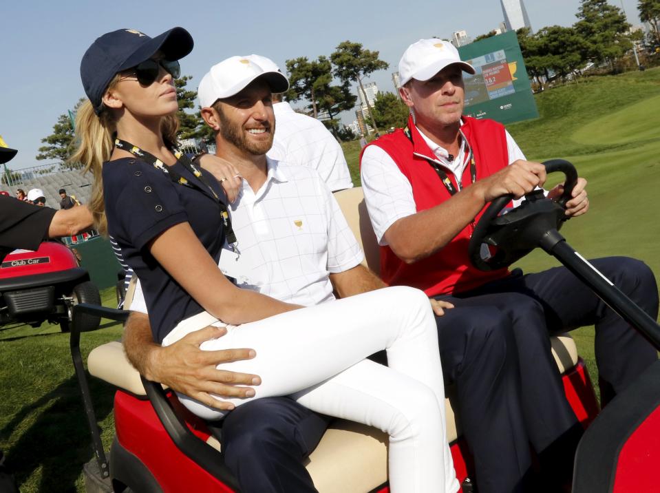 U.S. team member Johnson rides on a golf cart with his fiance Gretzky during the opening foursome matches of the 2015 Presidents Cup golf tournament in Incheon