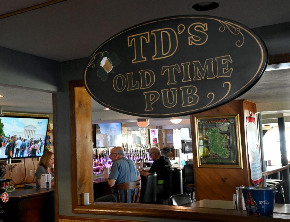 Customers at the bar are reflected in a mirror at TD's Old Time Pub in Milford, June 24, 2022.