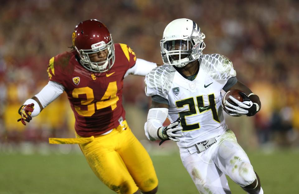 Running back Kenjon Barner #24 of the Oregon Ducks carries the ball against linebacker Tony Burnett #34 of the USC Trojans in the third quarter at the Los Angeles Memorial Coliseum on November 3, 2012 in Los Angeles, California. Oregon won 62-51. (Photo by Stephen Dunn/Getty Images)