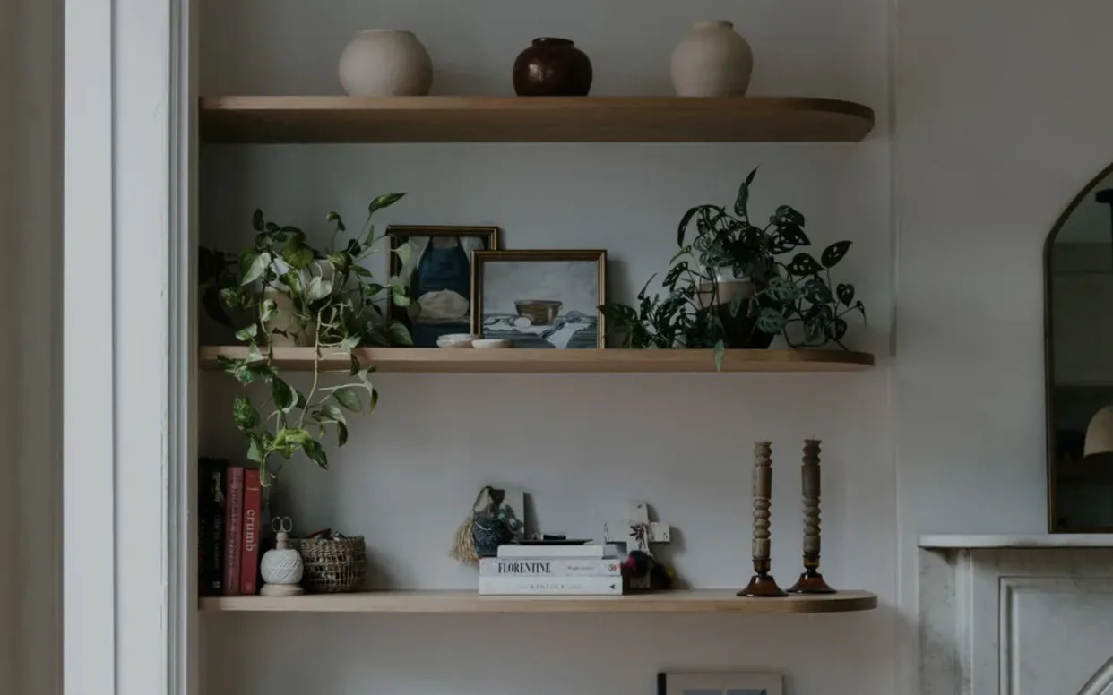 Wood floating shelves with rounded edge and styled with books and objects.