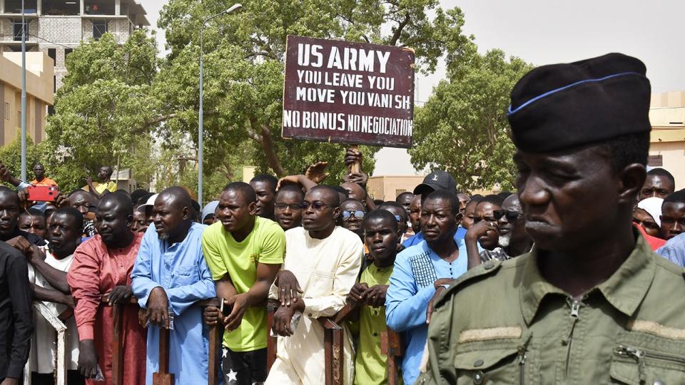 Protesters gather as a man holds up a sign demanding that soldiers from the United States Army leave Niger without negotiation during a demonstration in Niamey, on April 13, 2024. Thousands of people demonstrated on April 13, 2024, in Niger's capital, Niamey, to demand the immediate departure of American soldiers based in northern Niger, after the military regime said it was withdrawing from a 2012 cooperation deal with Washington.