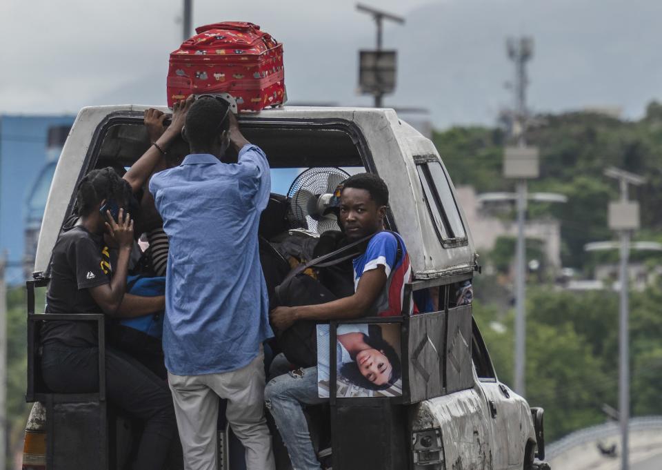 Residents use a public transport vehicle known as a tap-tap as they evacuate from the Delmas 22 neighborhood, with luggage and photos, to escape gang violence in Port-au-Prince, Haiti, Thursday, May 2, 2024. (AP Photo/Ramon Espinosa)