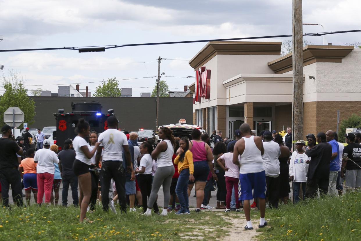 A crowd gathers as police investigate after a shooting at a supermarket on Saturday, May 14, 2022, in Buffalo, N.Y. Multiple people were shot at the Tops Friendly Market. Police have notified the public that the alleged shooter was in custody.