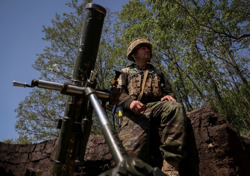 FILE PHOTO: A Ukrainian service member prepares to fire a mortar at a front line near the city of Bakhmut