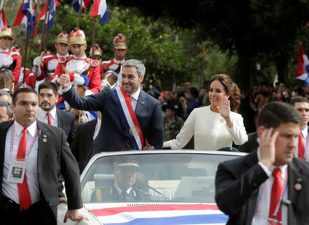 Paraguay's new President Mario Abdo Benitez gestures to the public as he rides in an open car alongside Paraguay's first lady Silvana Lopez Moreira after his inauguration ceremony in Asuncion, Paraguay August 15, 2018. REUTERS/Jorge Adorno