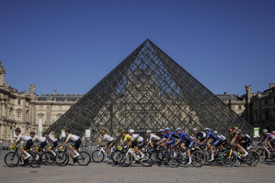 Slovenia's Tadej Pogacar, wearing the overall leader's yellow jersey, rides in front of The Louvre Museum with his UAE Team Emirates teammates during the twenty-first and last stage of the Tour de France cycling race over 108.4 kilometers (67.4 miles) with start in Chatou and finish on the Champs Elysees in Paris, France, Sunday, July 18, 2021. (Yoan Valat/Pool Photo via AP)