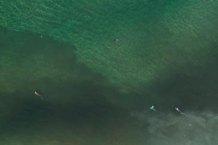<p>This July 5, 2016 photo, shows an aerial view of surfers paddling into the polluted waters off Sao Conrado beach in Rio de Janeiro, Brazil. “It’s been decades and I see no improvement,” laments biologist Mario Moscatelli, an activist who’s the most visible face of the fight to clean up Rio’s waterways. Guanabara Bay has been transformed in a latrine … and unfortunately Rio de Janeiro missed the opportunity, maybe the last big opportunity’ to clean it up. (AP Photo/Felipe Dana)