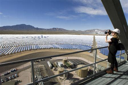 Katie Kukulka, an information officer with the California Energy Commission, takes photos during a tour of the Ivanpah Solar Electric Generating System in the Mojave Desert near the California-Nevada border February 13, 2014. REUTERS/Steve Marcus