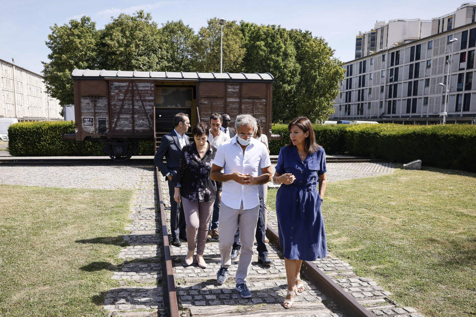 Paris mayor Anne Hidalgo, right, talks to Jacques Fredj, head of the Shoah Memorial ,as they leave the train car symbolizing the Drancy camp, at the Shoah memorial is photographed Tuesday, July 12, 2022 in Drancy, outside Paris. The Paris mayor and head of the French Holocaust Memorial will mark the 80th anniversary of the round-up of the Vel d'Hiv, the biggest Nazi roundup of Jews in France, visiting the site used as an internment camp during World War II for tens of thousands of people who were then sent on to Auschwitz and other death camps. (AP Photo/Thomas Padilla)