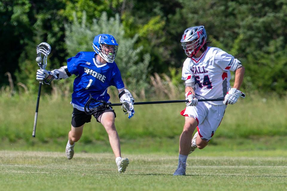 Shore Regional's Carson Cooke (1) is challenged by Wall's Billy Carr (54) during the Shore Conference Tournament boys lacrosse quarterfinals at the Wall Township High School in Wall, NJ Tuesday, May 25, 2021.