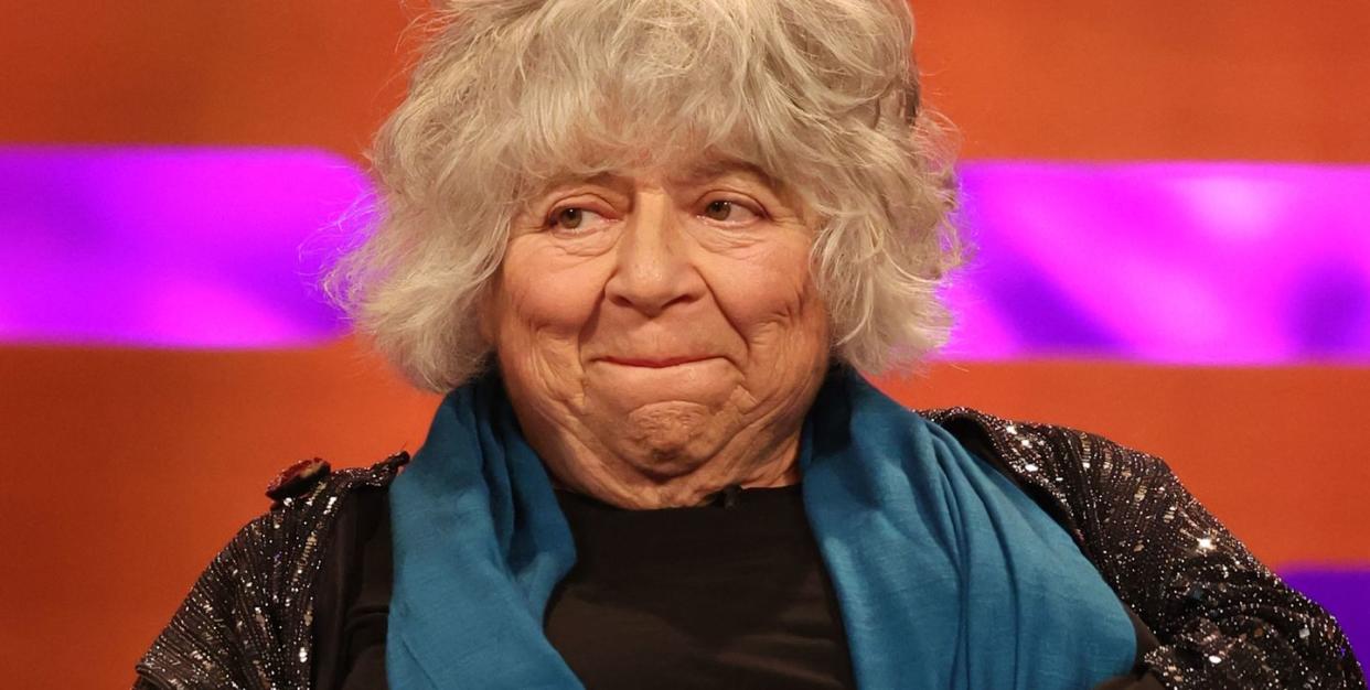 miriam margolyes on the graham norton show, an older woman bites her lip on a chat show