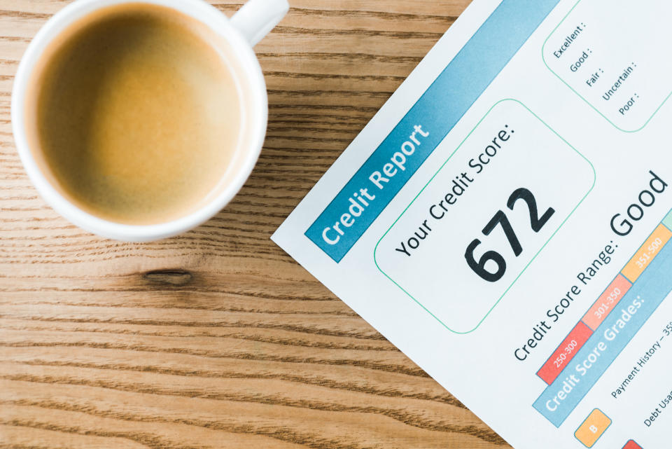 top view of cup with coffee near paper with credit report lettering on paper