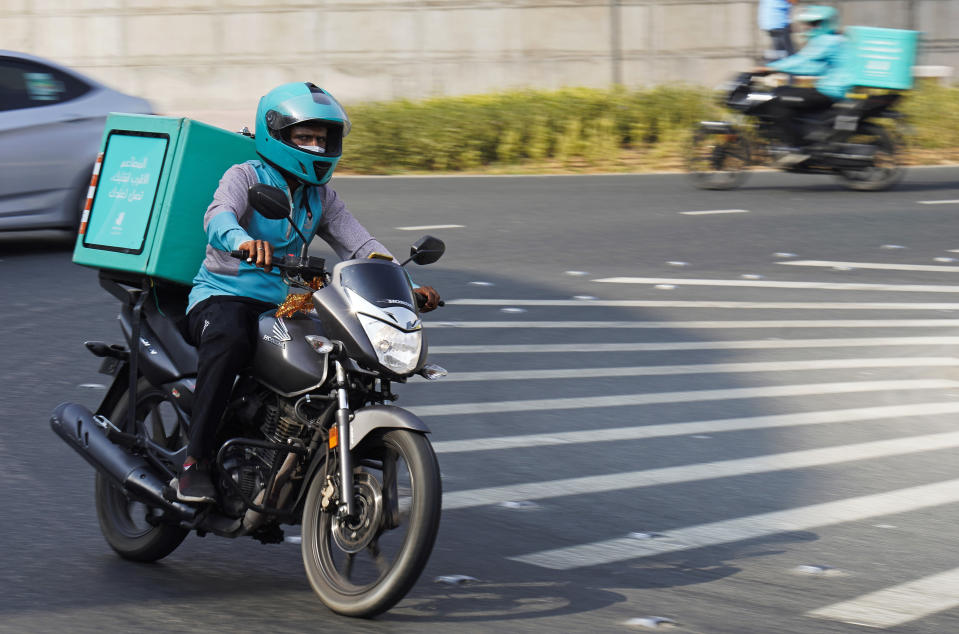 A delivery driver for the app Deliveroo speeds through a roundabout, in Dubai, United Arab Emirates, Thursday, Sept. 9, 2021. Advocates and workers say that casualties among food delivery riders are mounting in the city of Dubai, as the pandemic accelerates a boom in customer demand. The trend has transformed Dubai’s streets and drawn thousands of desperate riders, predominantly Pakistanis, into the high-risk, lightly regulated and sometimes-fatal work. (AP Photo/Jon Gambrell)