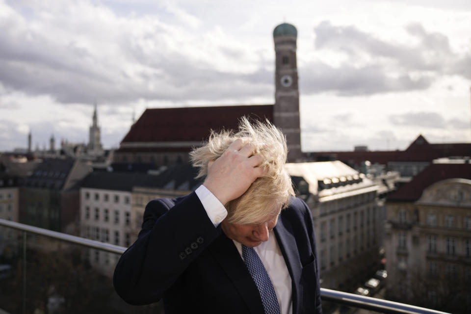 Britain's Prime Minister Boris Johnson rubbing his hair to get ready for a interview during the Munich Security Conference in Munich, Germany, Saturday, Feb. 19, 2022. (AP Photo/Matt Dunham, Pool)