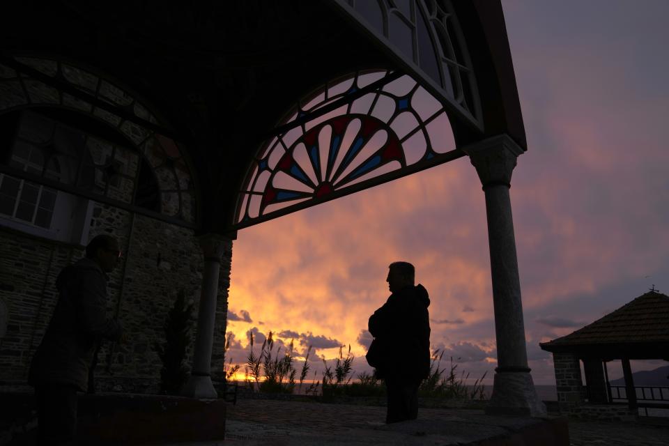 Male visitors talk as the sun rises from the sea at the Pantokrator Monastery in the Mount Athos, northern Greece, on Friday, Oct. 14, 2022. The monastic community was first granted self-governance through a decree by Byzantine Emperor Basil II, in 883 AD. Throughout its history, women have been forbidden from entering, a ban that still stands. This rule is called "avaton" and the researchers believe that it concerns every form of disturbance that could affect Mt. Athos. (AP Photo/Thanassis Stavrakis)