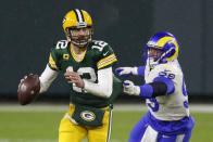 Green Bay Packers quarterback Aaron Rodgers (12) throws under pressure from Los Angeles Rams' Aaron Donald (99) during the first half of an NFL divisional playoff football game Saturday, Jan. 16, 2021, in Green Bay, Wis. (AP Photo/Matt Ludtke)
