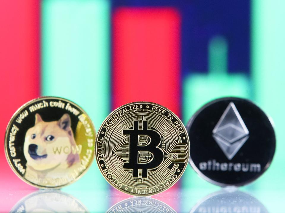 Bitcoin, Dogecoin, Ethereum cryptocurrency coins and a graph are pictured in Kyiv on 08 July, 2021.