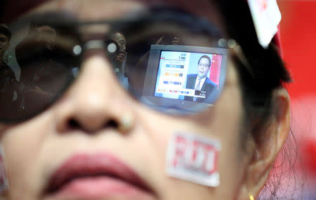 Live results are reflected in glasses of a supporter of Pheu Thai Party during the general election in Bangkok, Thailand, March 24, 2019. REUTERS/Athit Perawongmetha
