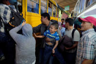 People in a caravan of migrants departing from El Salvador en route to the United States wait to board a bus, in San Salvador, El Salvador, November 18, 2018. REUTERS/Jose Cabezas