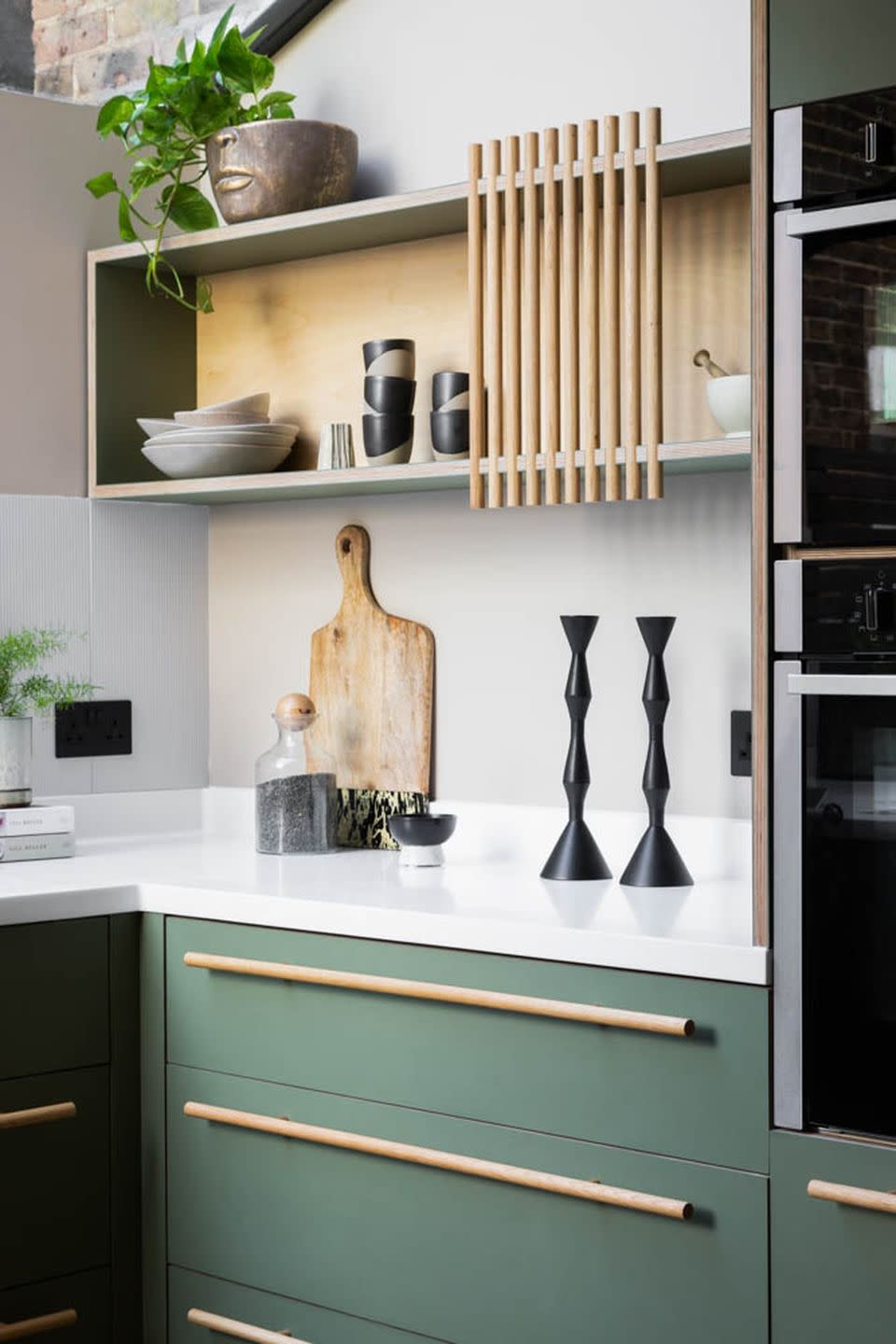 a kitchen with a shelf and a plant on the wall