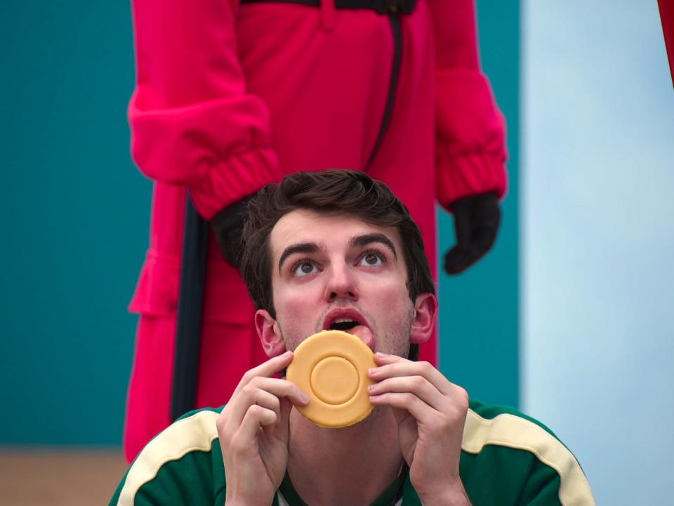 Trey Plutnicki licking a round cookie