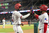 Texas Rangers' Jurickson Profar, front left, is congratulated by Elvis Andrus after scoring on a bases-loaded walk of Shin-Soo Choo by Los Angeles Angels relief pitcher Justin Anderson during the eighth inning of a baseball game Thursday, Aug. 16, 2018, in Arlington, Texas. Texas won 8-6. (AP Photo/Jeffrey McWhorter)