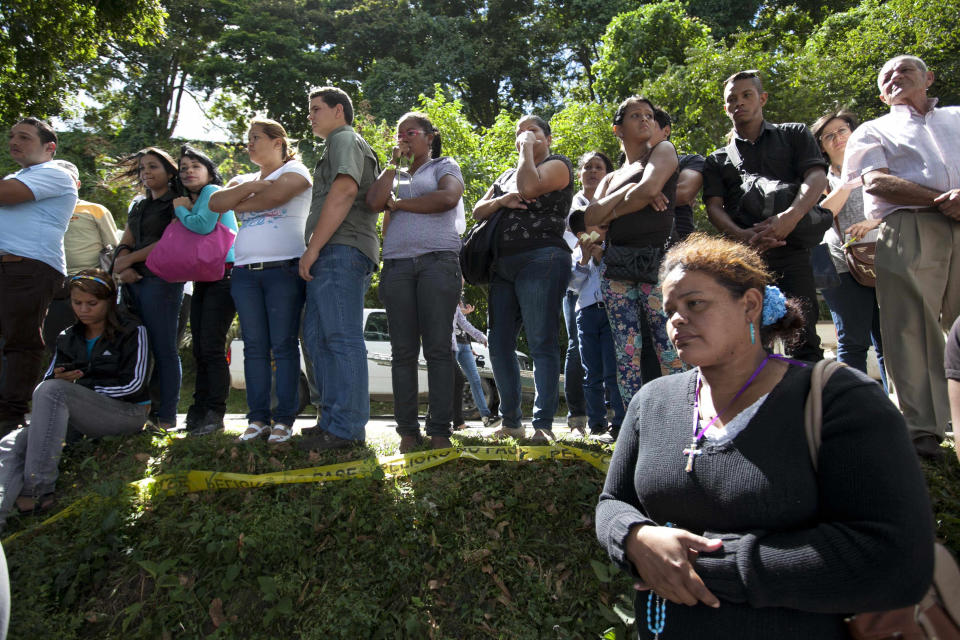 People attend the funeral of former Miss Venezuela Monica Spear and her ex-husband Thomas Henry Berry at the East Cemetery in Caracas, Venezuela, Friday, Jan. 10, 2014. Robbers killed actress Spear, 29, and her former husband Berry, 39, late Monday night on an isolated stretch of highway while the couple was returning to the capital by car with their 5-year-old daughter from a vacation. (AP Photo/Alejandro Cegarra)