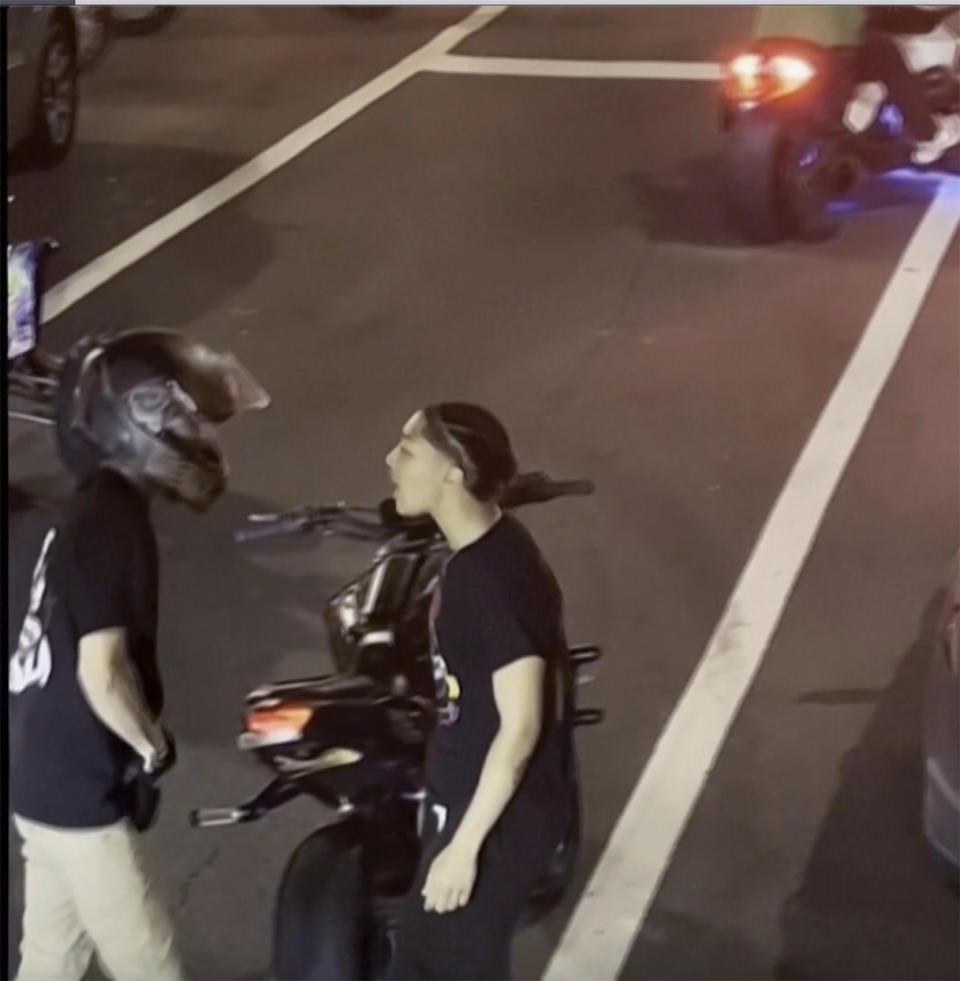 This image provided by George Coloney/@Vortex.hz shows a shows a biker being confronted after smashing the car’s back window on Sunday, Oct. 1, 2023 in Philadelphia. According to authorities, Cody Heron is accused of being the motorcyclist seen smashing in the back of a woman's car while her two young children were inside near Philadelphia's City Hall and then waving a gun at her after she confronted him has been charged with multiple counts of aggravated assault. (Courtesy of George Coloney/@Vortex.hz via AP)