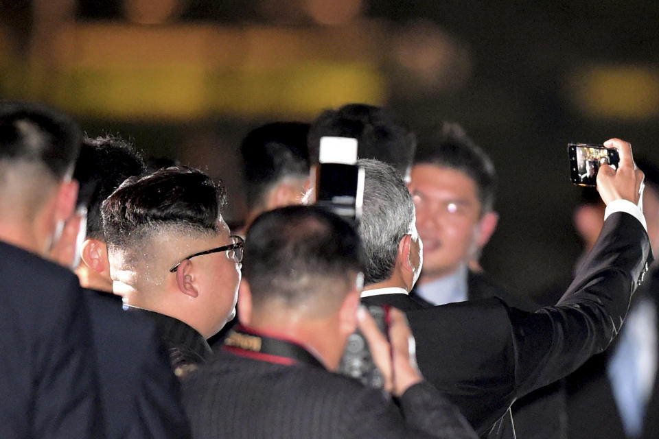 North Korean leader Kim Jong Un, seen from back, takes a selfie with Balakrishnan as they walk on the Jubilee Bridge as he tours Singapore. Source: AP