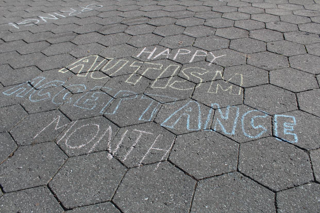 A sidewalk chalk drawing celebrates Autism Acceptance Month in April.