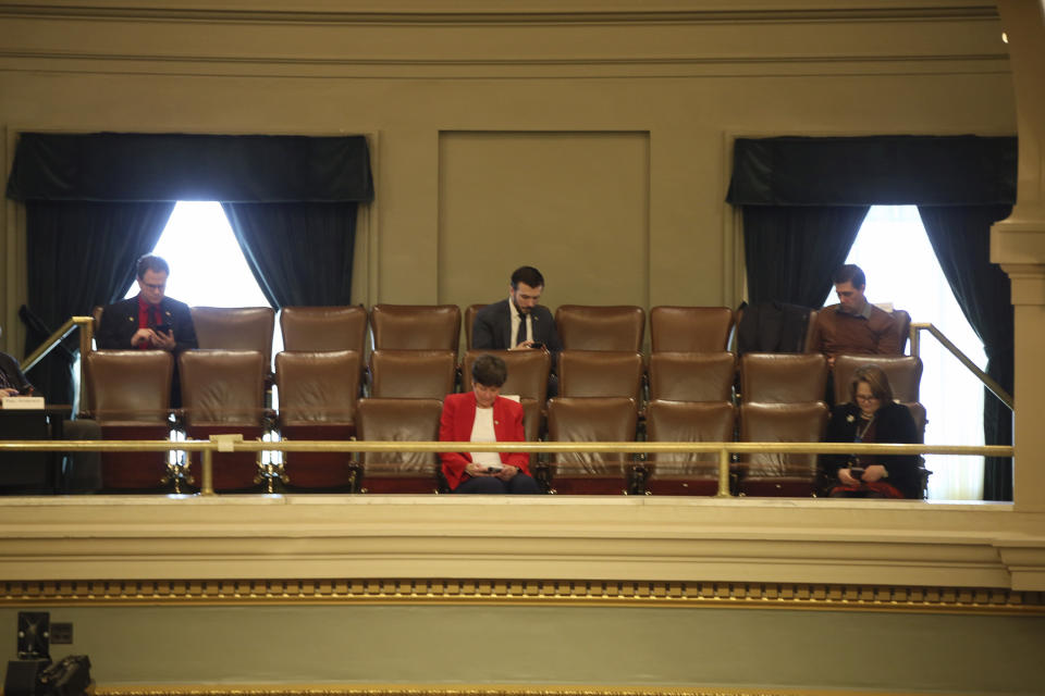 FILE - In this March 26, 2020 file photo, several Lawmakers in the Minnesota House practice social distancing from a gallery at the State Capitol in St. Paul, Minn. as representatives met to take up bills related to the coronavirus in the state. In state capitols across the U.S., lawmakers have ditched decorum and sidestepped traditional public meeting requirements in a rush to pass legislation funding the fight against the coronavirus and aiding residents affected by the widespread shut down of commerce. (AP Photo/Jim Mone, File)