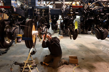 Soybean farmer Austin Rincker makes a modification to his planter as he installs a high speed planting conversion component in Moweaqua, Illinois, U.S., March 6, 2019. Rincker will farm approximately 2500 acres in the upcoming season, split evenly between corn and soybeans. Picture taken March 6, 2019. REUTERS/Daniel Acker