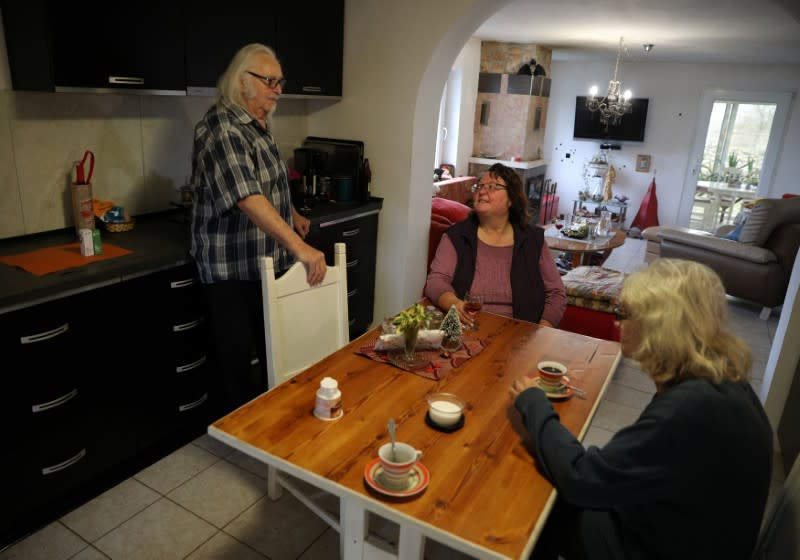 Waldemar Hackstaetter and his wife Hildegard chat with their neighbour Brigitte Haager-Horn in their house in the village of Sirakovo