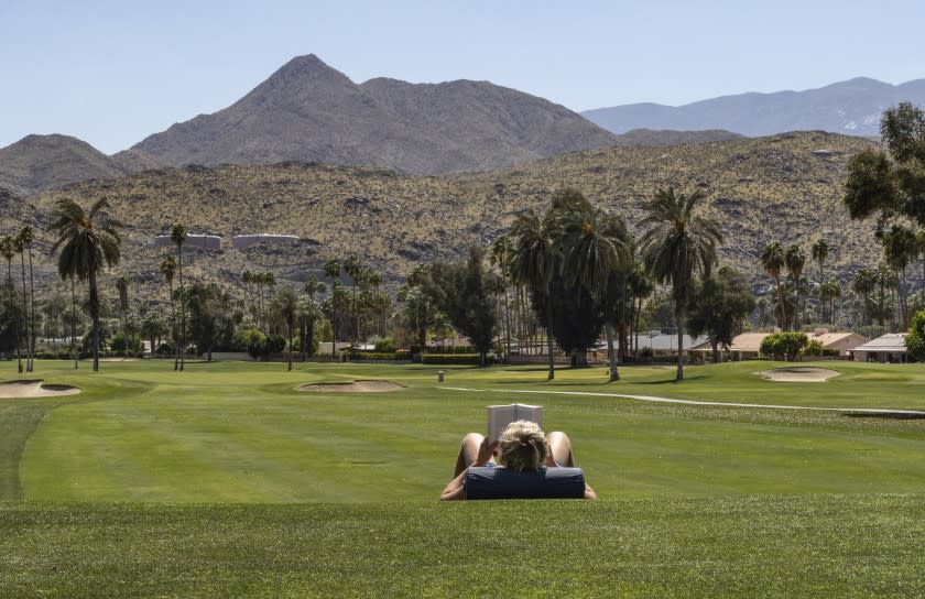 PALM SPRINGS, CALIFORNIA - APRIL 3, 2020: A Palm Springs resident finds the serenity of a closed golf course the perfect place for afternoon reading during the coronavirus pandemic at Tahquitz Creek Golf Resort on April 3, 2020 in Palm Springs. All the golf courses are closed in the desert communities. Declining to give his name, he said he's reading a novel by German philosopher Friedrich Nietzsche. Which seems very relevant during these times. Some of Nietzsche's famous quotes are, "To live is to suffer, to survive is to find meaning in the suffering," and "That which does not kill us makes us stronger." Also, "Without music, life would be a mistake."