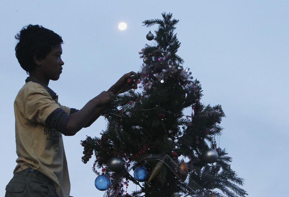 Ruben Miraflor, a survivor of Super Typhoon Haiyan, decorates Christmas tree placed along main street at Magallanes town in Tacloban