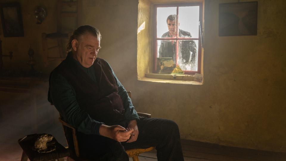 Padraic looking through the window at Colm, sitting inside his cottage