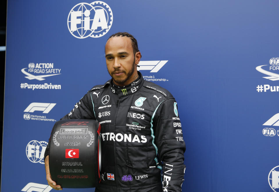 Mercedes driver Lewis Hamilton of Britain, with his award for winning pole position after the end of qualifying for Sunday's Formula One Turkish Grand Prix at the Intercity Istanbul Park circuit in Istanbul, Turkey, Saturday, Oct. 9, 2021. Hamilton who took pole position will start 10th due to a penalty with Mercedes driver Valtteri Bottas of Finland who came second promoted to pole, for the race. (Umit Bektas/Pool Photo via AP)