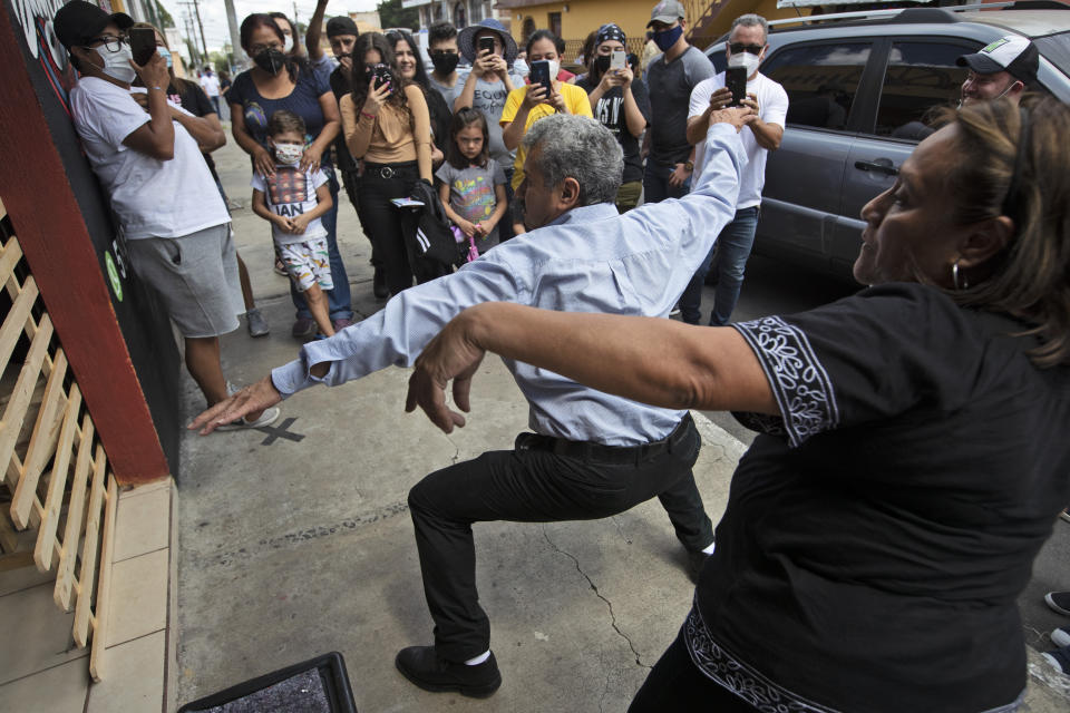 Fabio Rodolfo Vasquez and his wife, Maria Moreno, dance at a promotional event outside a coffee shop on the outskirts of Guatemala City, Saturday, Sept. 19, 2020. The couple met in a Guatemala City club more than 30 years ago when they won a dance contest. (AP Photo/Moises Castillo)