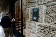 A man drops an envelope addressed to Carlos Ghosn through the entrance gate of what is believed to be Ghosn's house in Beirut