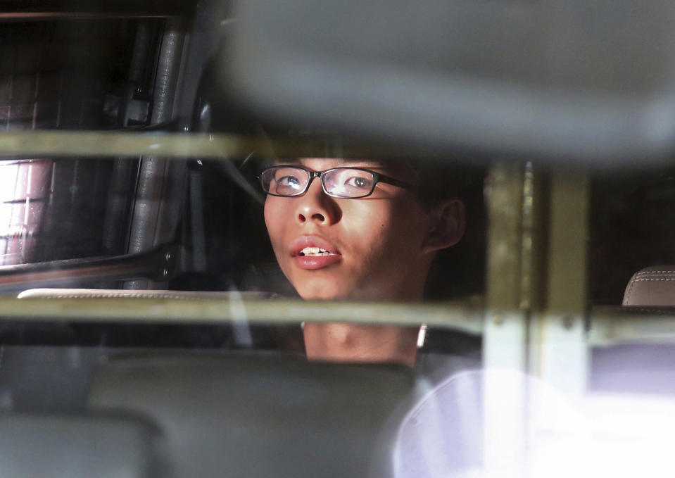 FILE - In this Aug. 17, 2017, file photo, Hong Kong activist Joshua Wong is taken away in a prison bus leaving the high court after his sentencing in Hong Kong, Overseas, Joshua Wong has emerged as a prominent face of Hong Kong's months-long protests for full democracy. At home, he is just another protester. (AP Photo, File)