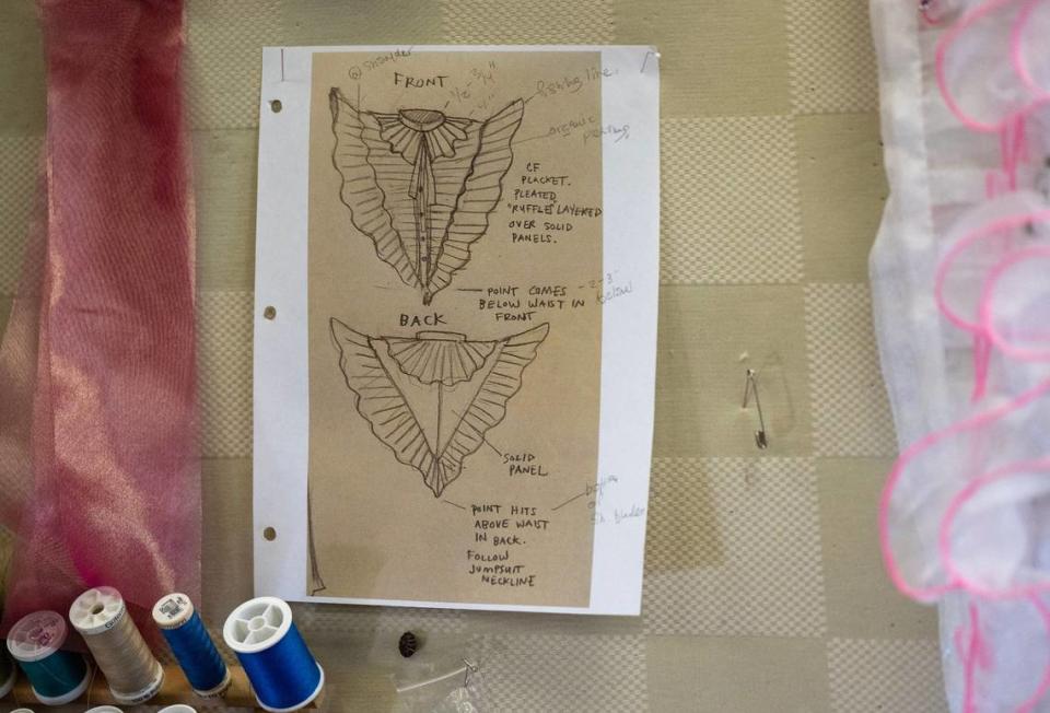 A sketch from Sully Ratke hangs with samples of fabric to be used to make the costume for actor Shon Ruffin, who portrays Audrey II in “Little Shop of Horrors.”