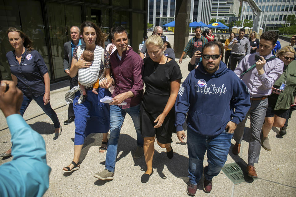 Michigan gubernatorial candidate Ryan Kelly leaves the U.S. District Court in Grand Rapids, Mich., with his family and supporters on Thursday, June 9, 2022. Kelley has been charged with four misdemeanors from his involvement with the riot at the Capitol Building in Washington, D.C., on Jan. 6, 2021. (Daniel Shular/The Grand Rapids Press via AP)