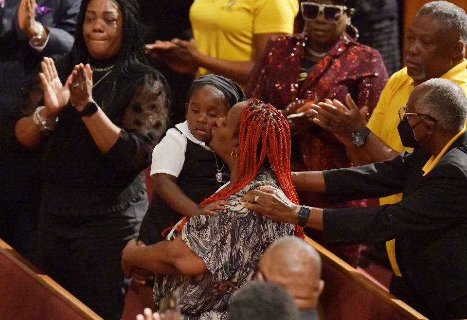 Sabrina Rozier kisses her granddaugher, Jeasia Gallion, 4, who is the daughter of shooting victim Jerrald Gallion as the family was recognized during Friday's memorial service for another of the shooting victims, Angela Carr, at The Bethel Baptist Church in Jacksonville.