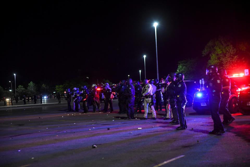 Sioux Falls police wear protective gear as they form a line in front of protesters on Sunday, May 31, 2020 in Sioux Falls, S.D.