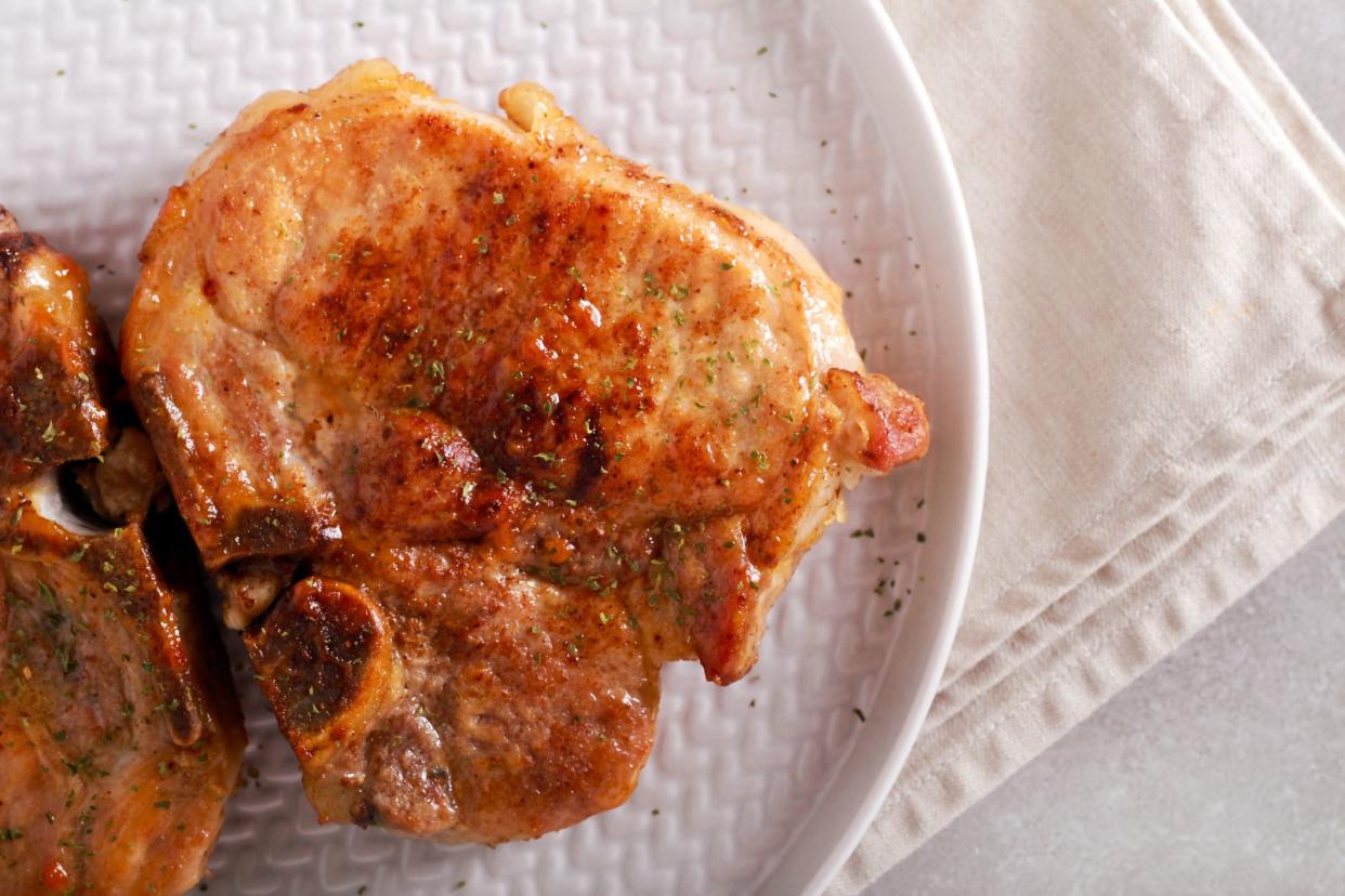 Fried pork steaks on plate, top view