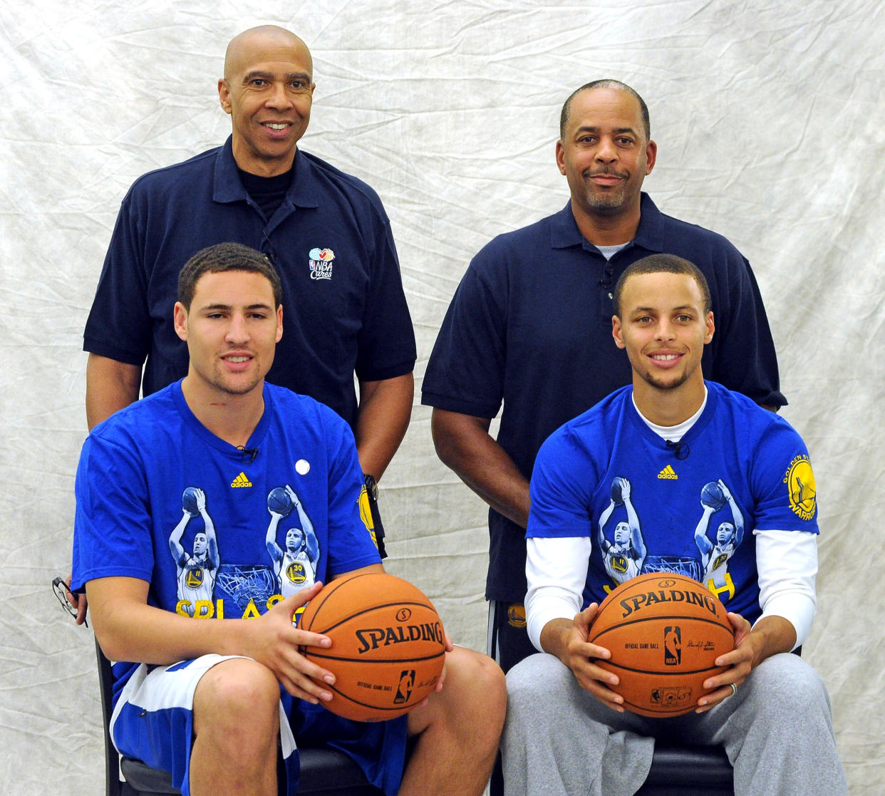 The Golden State Warriors team photographer takes a portrait of  Golden State Warriors players Klay Thompson, seated left and Stephen Curry, and their fathers former National Basketball Association players, Mychal Thompson, standing left and Dell Curry before the start of the SplashBrothers Clinic held at the Golden State Warriors training facility in Oakland, Calif., on Friday, Sept. 20, 2013. The clinic, presented by Kaiser Permanente, offered participants a basketball experience with Stephen Curry, Klay Thompson, and their fathers, Dell and Mychal. Proceeds from the event go to the Warriors Community Foundation. (Doug Duran/Bay Area News Group) (Photo by MediaNews Group/Bay Area News via Getty Images)