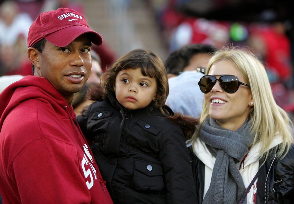 Tiger Woods holds his daugher, Sam, and stands next to his wife, Elin Nordegren, on the sidelines before the Cardinal game against the California Bears at Stanford Stadium on November 21, 2009 in Palo Alto, California