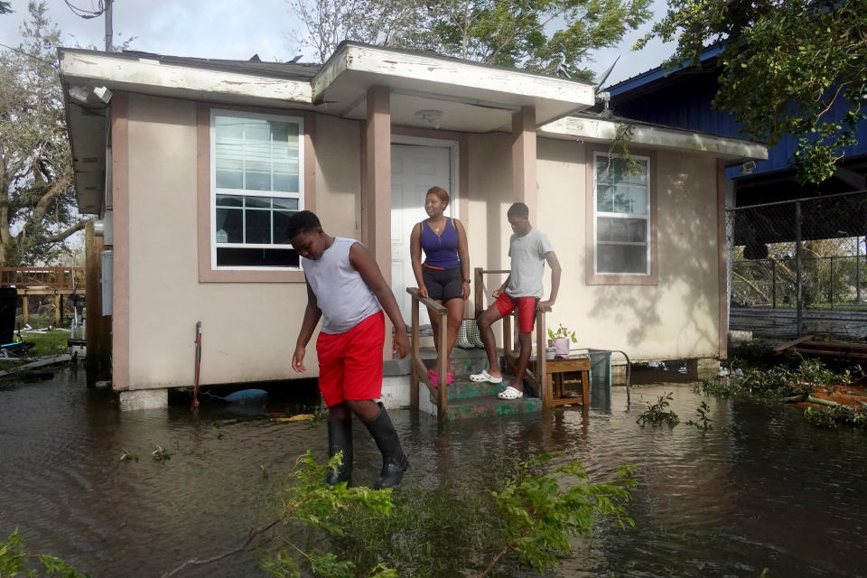 Michelle Washington and her sons Kendrick and Kayden check out damage to their home in the aftermath of Hurricane Ida