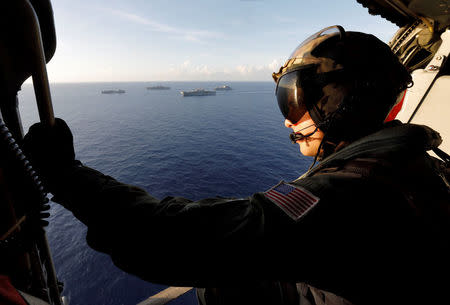 Naval air crewman Aaron Glaspell looks out on a flotilla of Navy vessels as they maneuver around Hurricane Maria before eventually returning to assist the U.S. Virgin Islands, in the Caribbean Sea September 19, 2017. REUTERS/Jonathan Drake